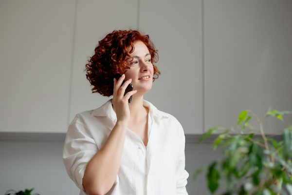 Pleasant talk with friend. Attractive redhead woman talking on cell phone .